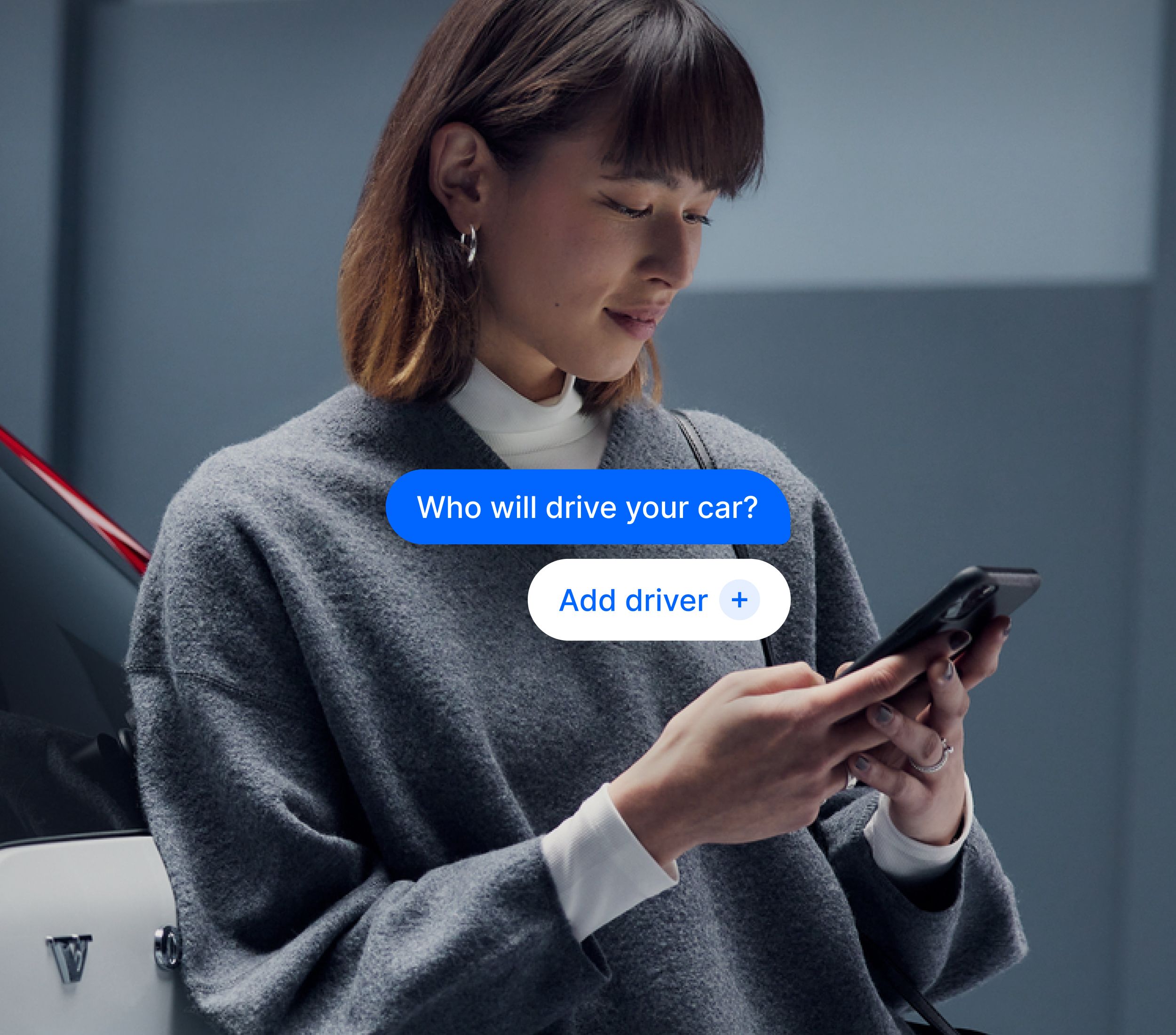 Person standing next to a car, using a smartphone, with an app interface asking, “Who will drive your car?”